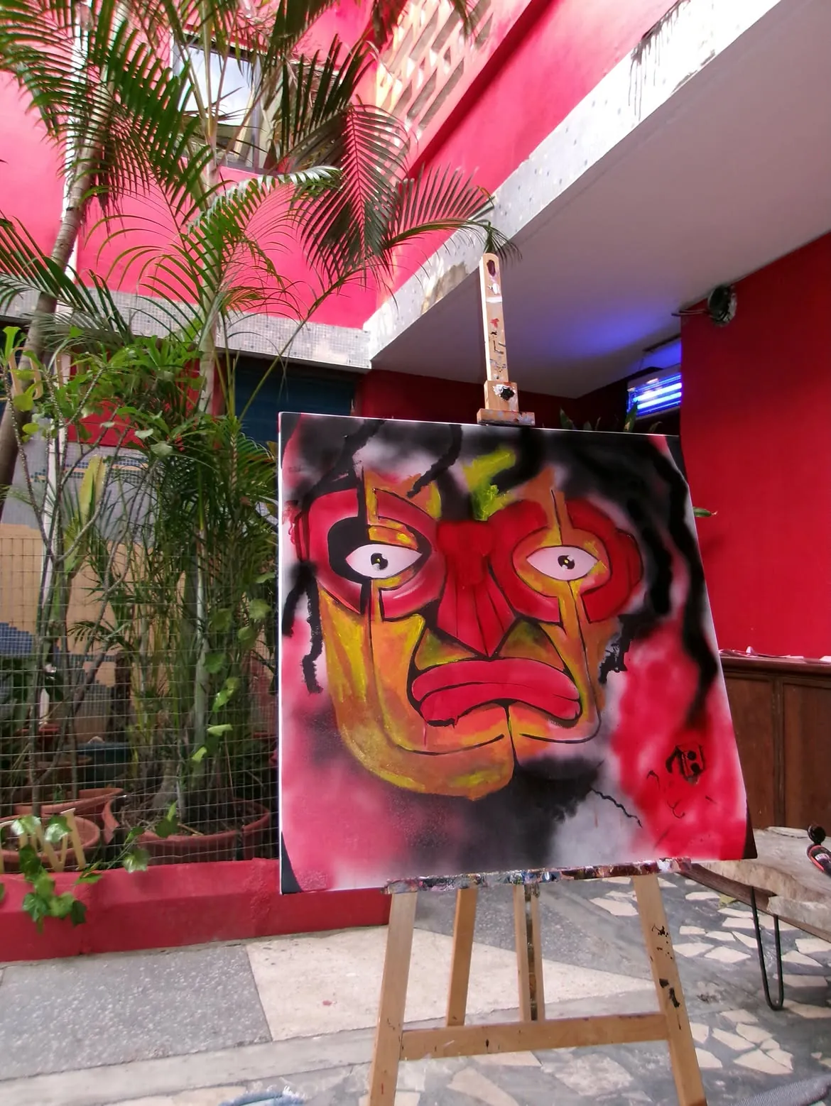 Colorful artwork between potted palms