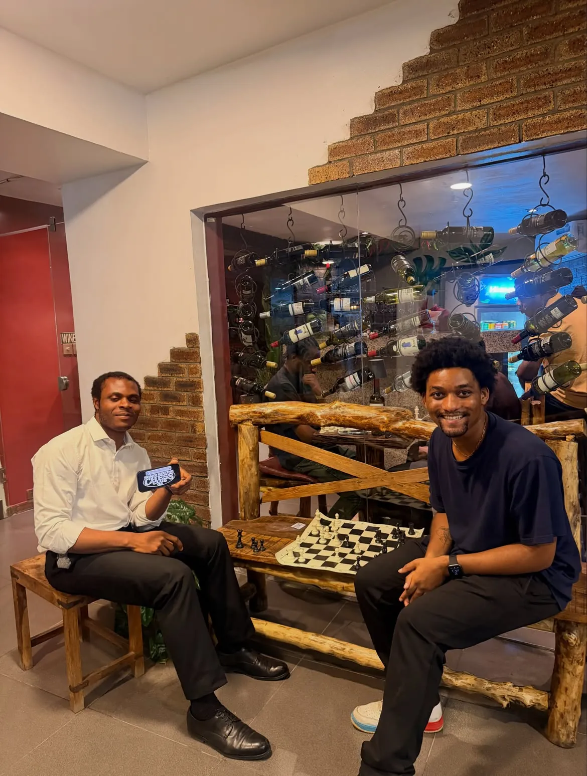 Two players beside the bottle-lined wall