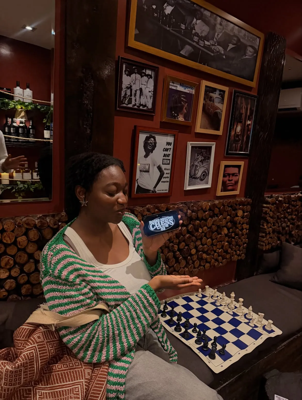 A guest playing chess beneath framed portraits