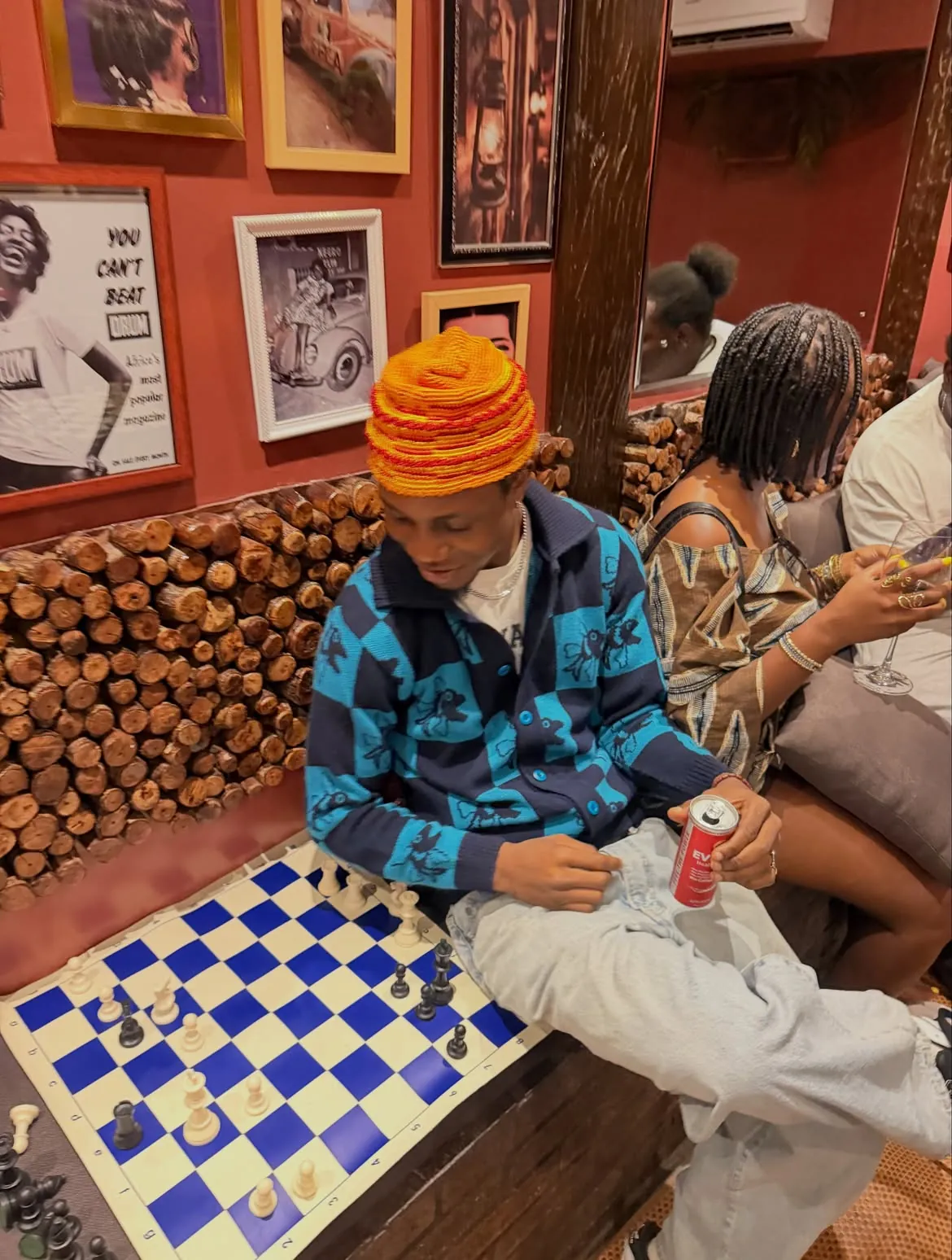 A guest in a colorful cap at the chessboard
