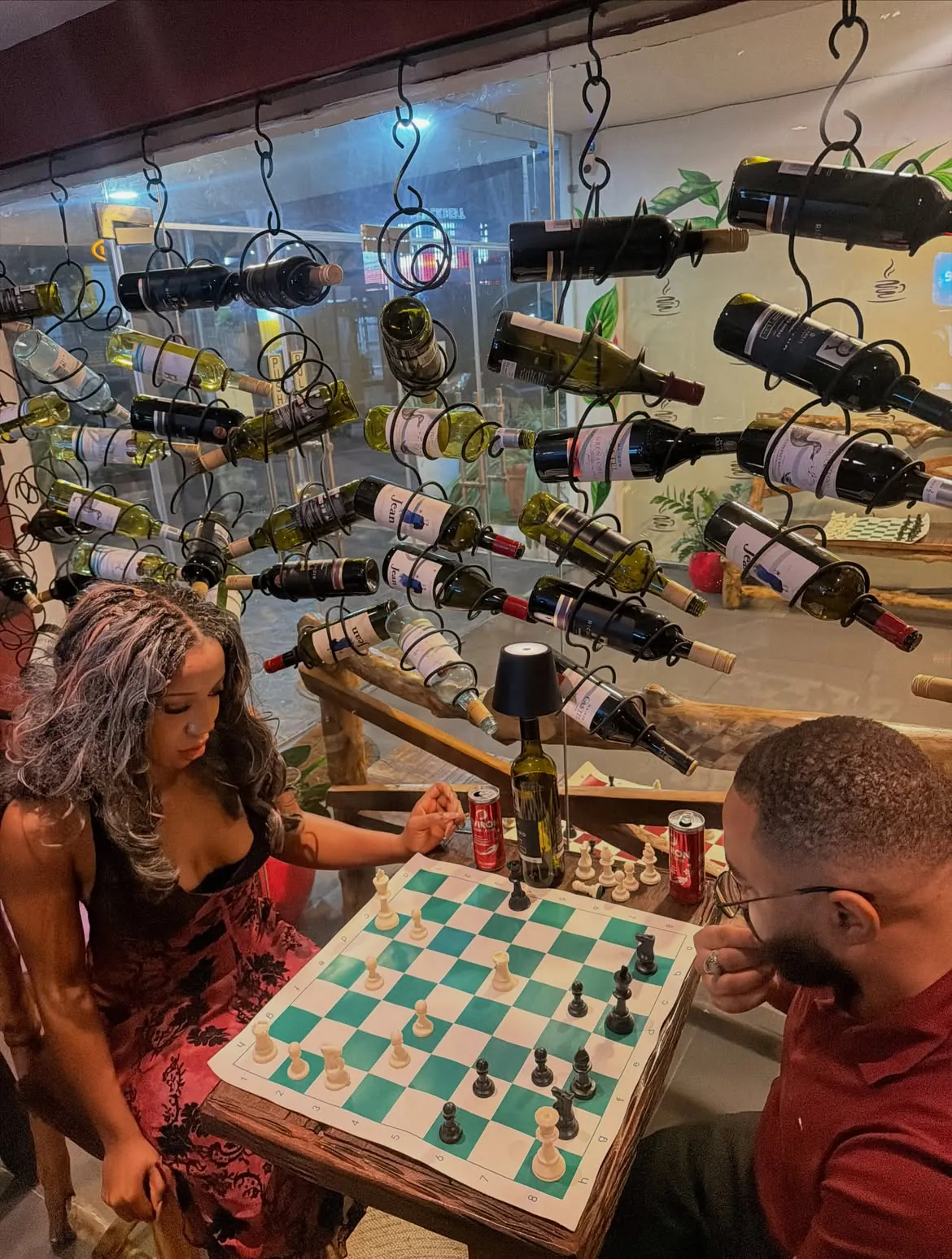 Two guests playing beside the bottle-lined wall